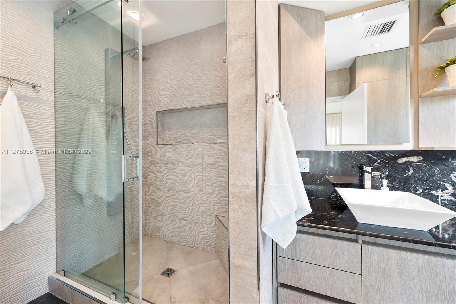 940 88th Street Surfside, FL 33154 - Photo 34 of 38 a bathroom with a sink and mirror