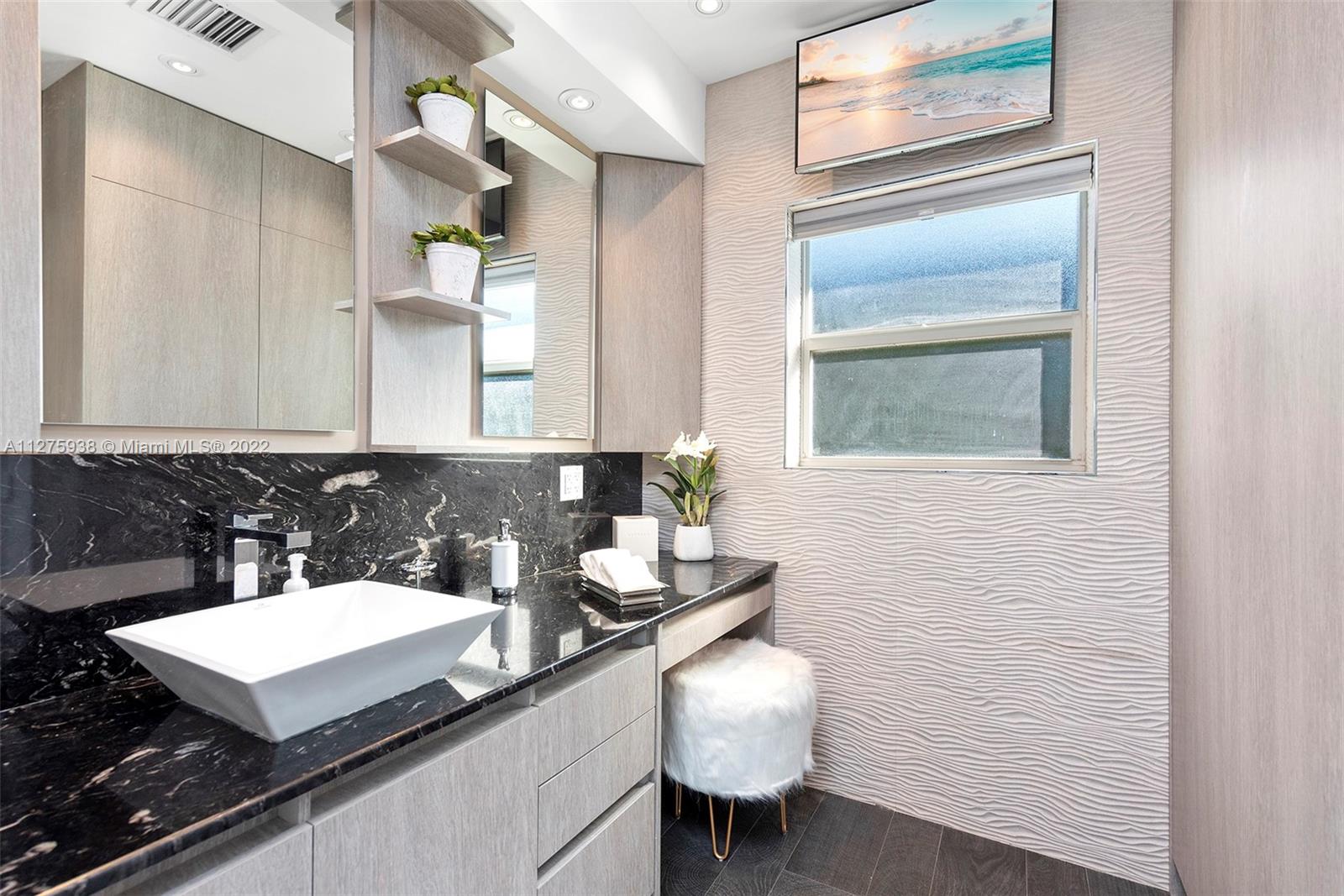 940 88th Street Surfside, FL 33154 - Photo 35 of 38 a bathroom with a sink and a mirror