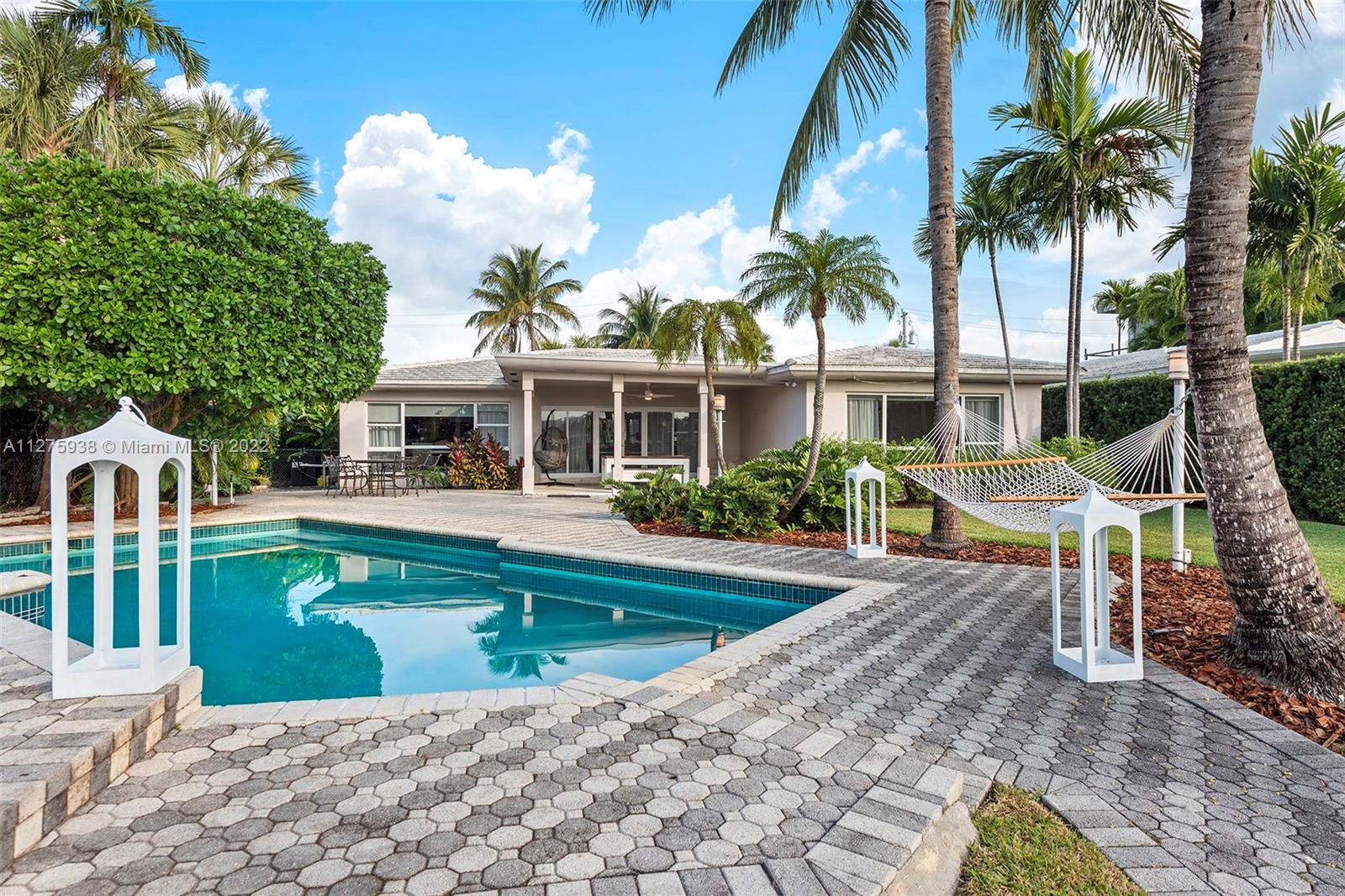 940 88th Street Surfside, FL 33154 - Photo 4 of 38 a front view of a house with swimming pool having outdoor seating