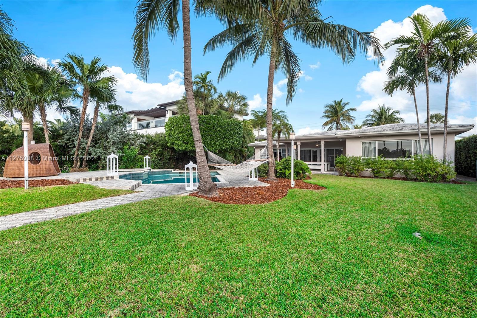 940 88th Street Surfside, FL 33154 - Photo 7 of 38 a view of a house with a swimming pool and a garden