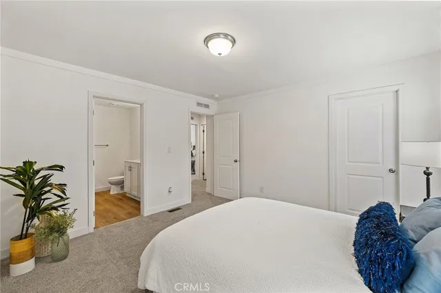 a bedroom with a bed and a potted plant