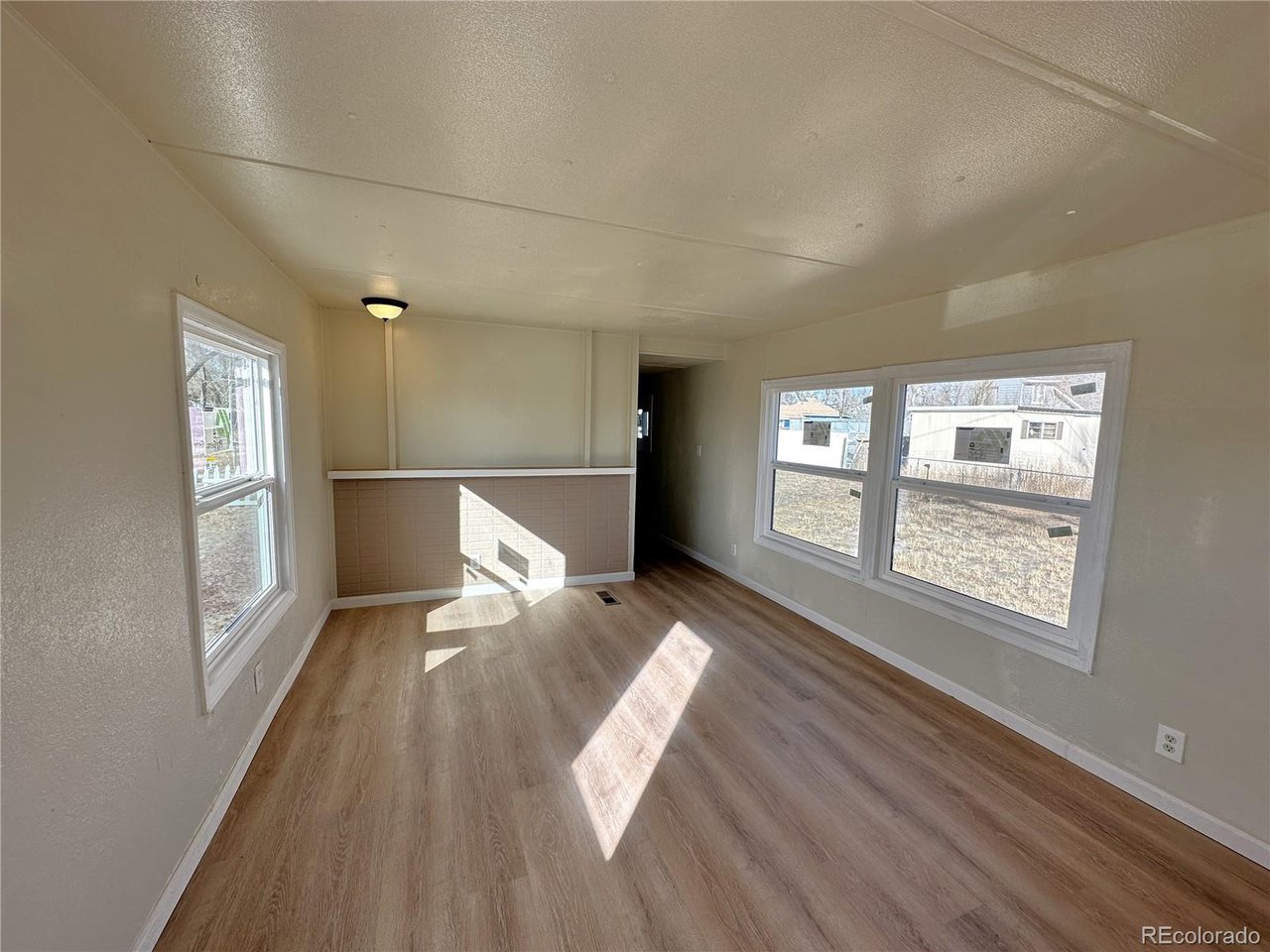 155 Indiana Avenue Limon, CO 80828 - Photo 11 of 27 a view of an empty room with wooden floor and a window