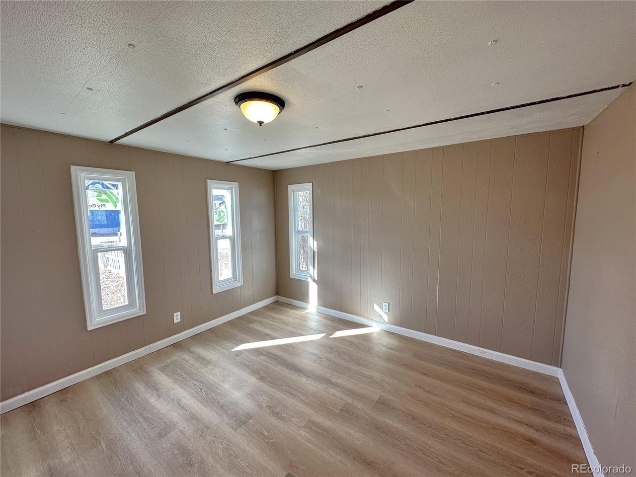 155 Indiana Avenue Limon, CO 80828 - Photo 13 of 27 a view of an empty room with wooden floor and a window
