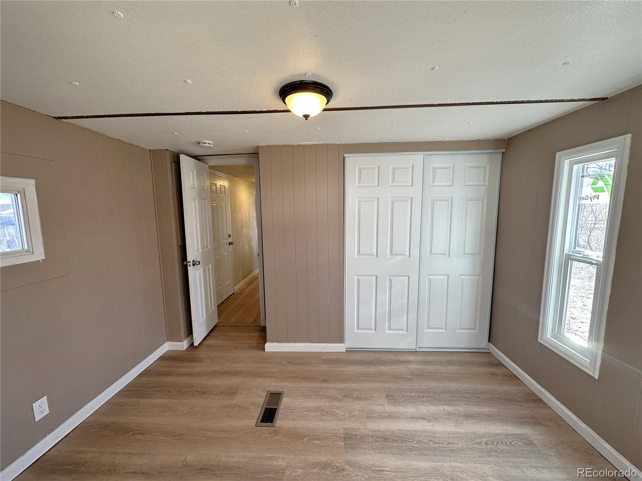 155 Indiana Avenue Limon, CO 80828 - Photo 15 of 27 an empty room with wooden floor and windows