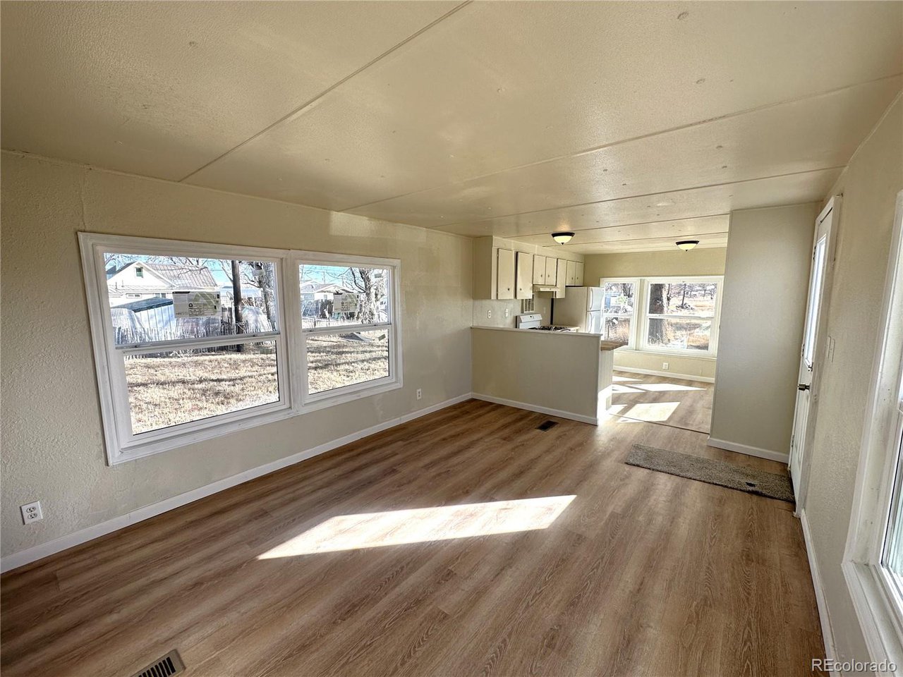 155 Indiana Avenue Limon, CO 80828 - Photo 4 of 27 an empty room with wooden floor and windows