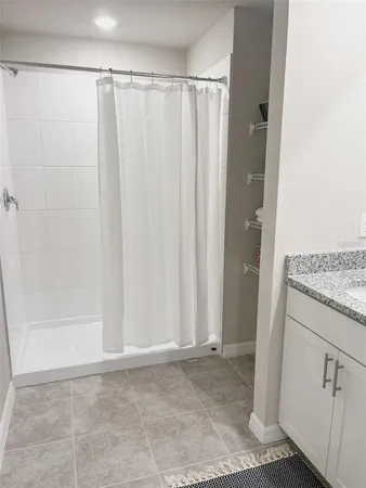 a bathroom with a granite countertop sink a mirror and a potted plant