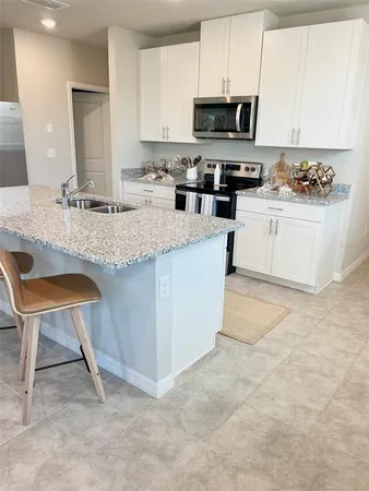 a kitchen with granite countertop cabinets and chairs