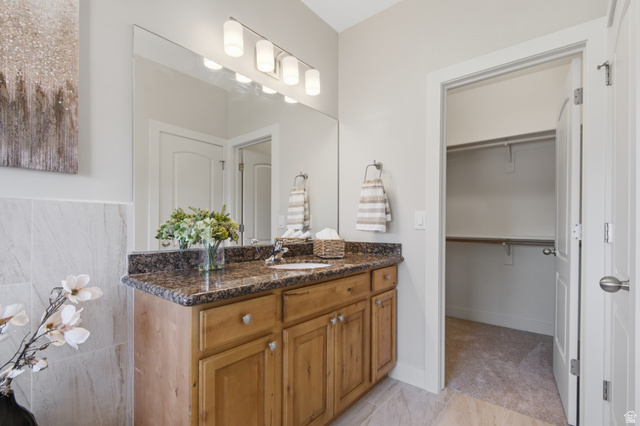 1252 Skyline Road Saratoga Springs, UT 84045 - Photo 20 of 51 Vanity with a granite countertop, undermount sink, and wood-finish cabinetry