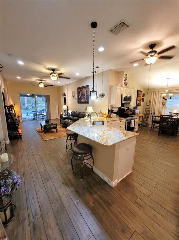 1001 Torreya Way Odessa, FL 33556 - Photo 8 of 44 a living room with stainless steel appliances kitchen island granite countertop a table chairs and a couch