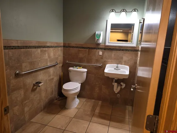 a bathroom with a toilet a sink and mirror