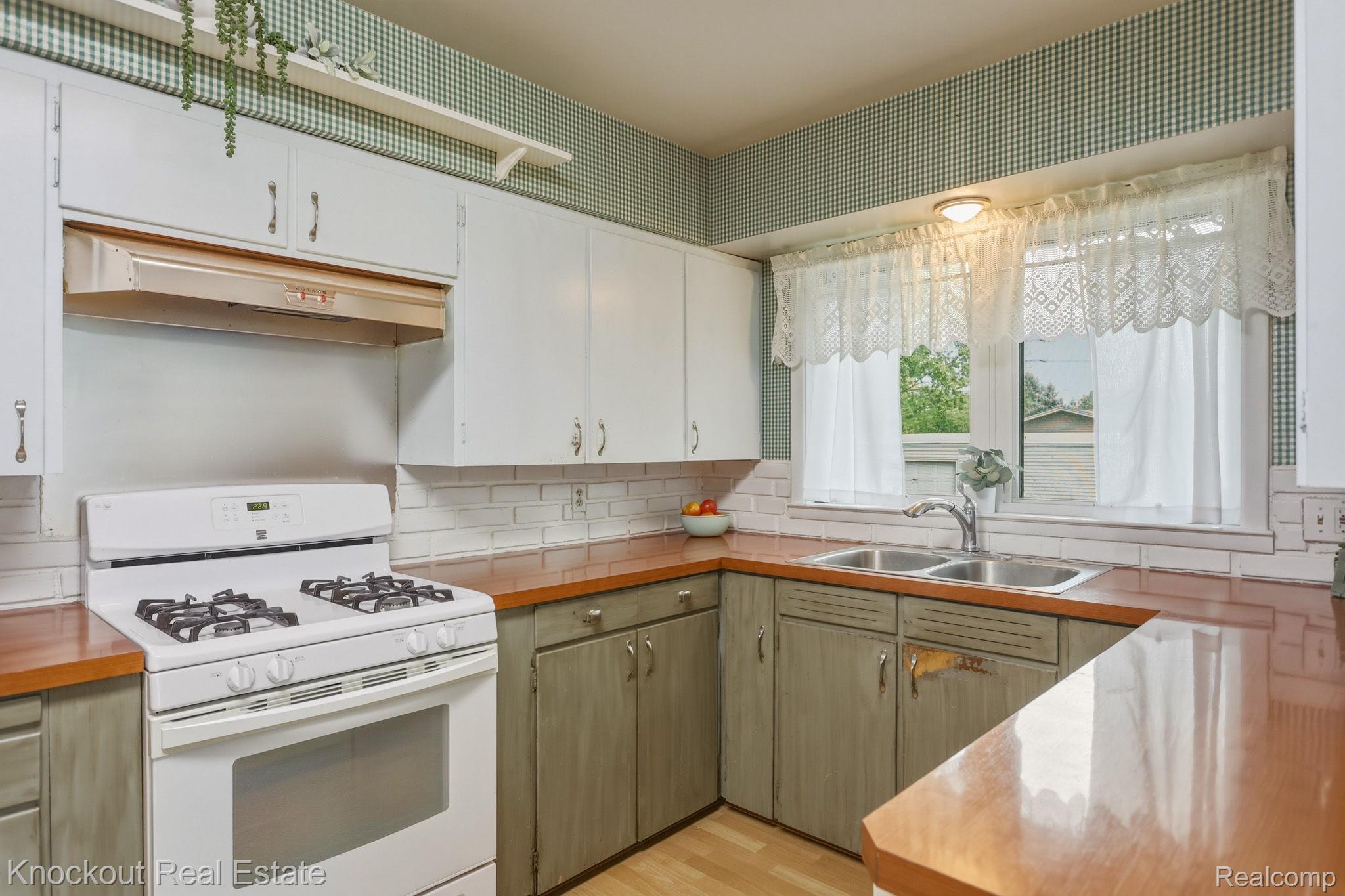 1755 South Reese Road Reese, MI 48757 - Photo 14 of 69 Kitchen featuring white upper cabinetry, painted lower cabinetry, wood-finish countertops, subway tile backsplash, and a double basin stainless steel sink