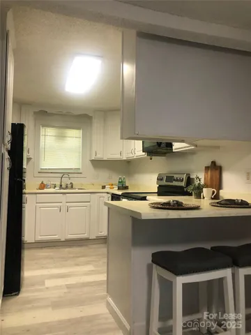 a kitchen with stainless steel appliances a sink stove and cabinets