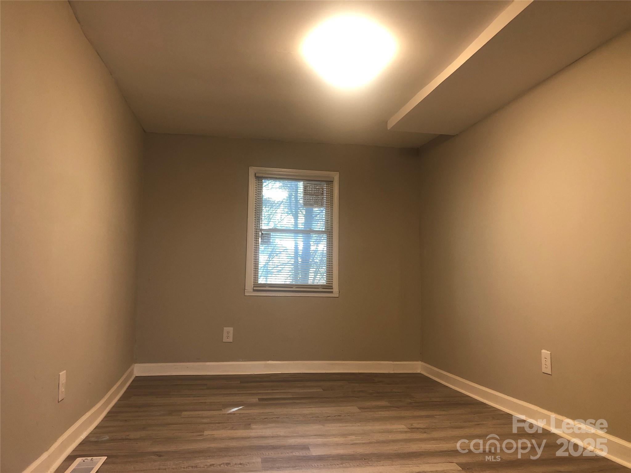 140 Winget Circle Gastonia, NC 28054 - Photo 6 of 16 an empty room with wooden floor and windows