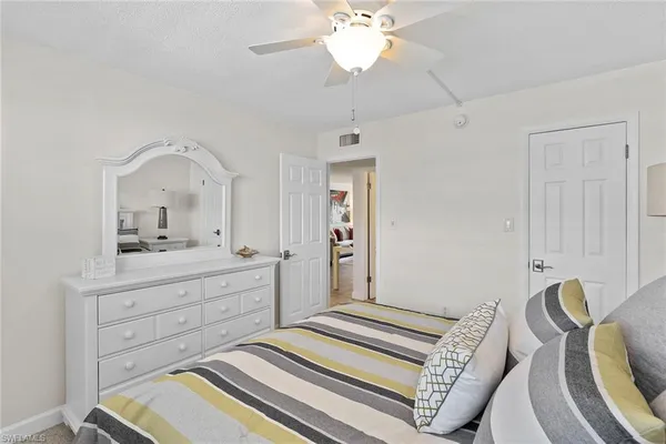 a spacious bedroom with a bed and a dresser