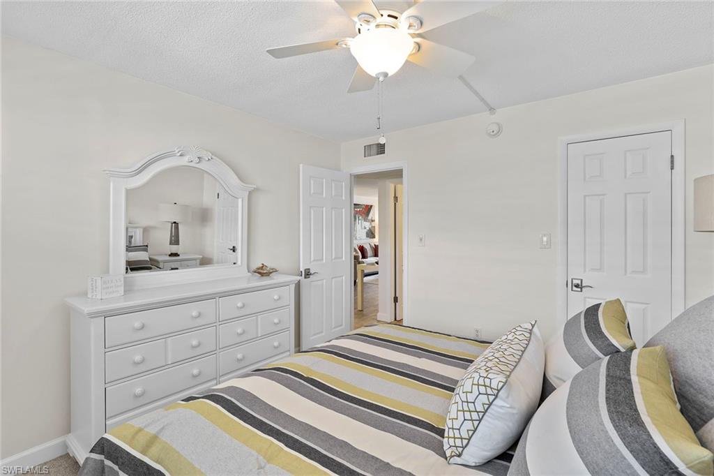 72 7th Street South, Unit 208 Naples, FL 34102 - Photo 13 of 21 a spacious bedroom with a bed and a dresser