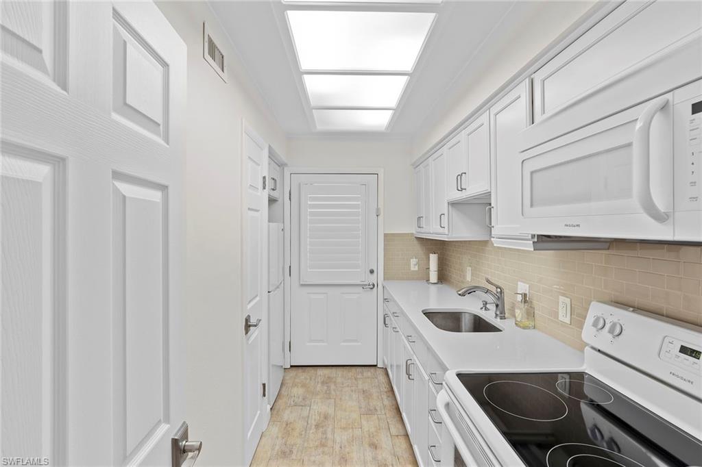 72 7th Street South, Unit 208 Naples, FL 34102 - Photo 10 of 21 a kitchen with a sink a stove and cabinets