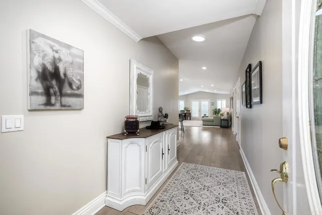a view of a dining room and livingroom with furniture wooden floor a chandelier