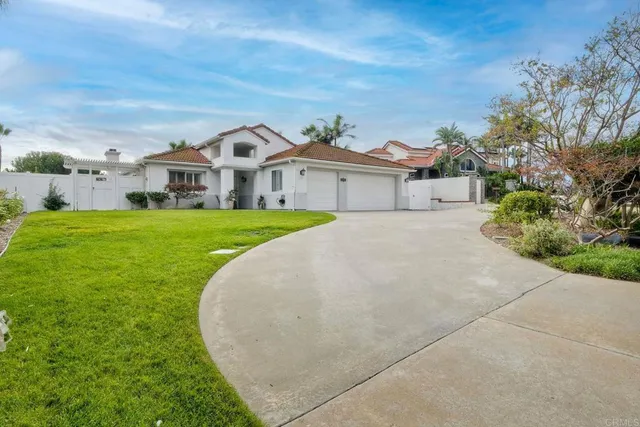 a front view of a house with a garden and trees