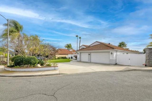 a view of a house with a yard and potted plants