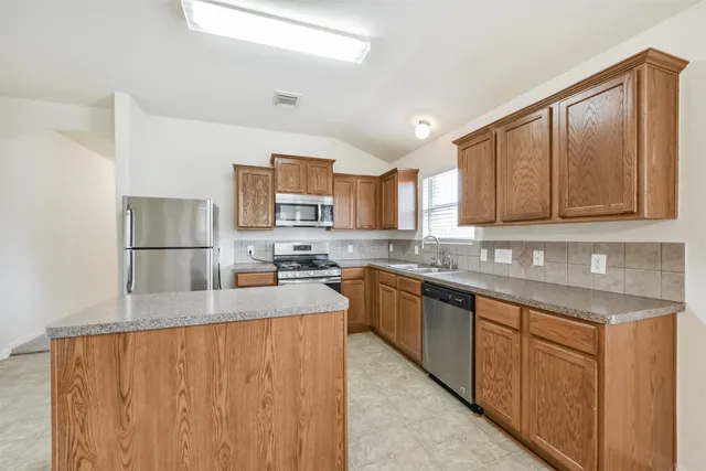 a kitchen with stainless steel appliances granite countertop a refrigerator sink and cabinets
