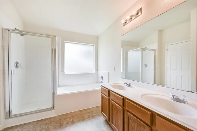 a spacious bathroom with a tub sink and mirror
