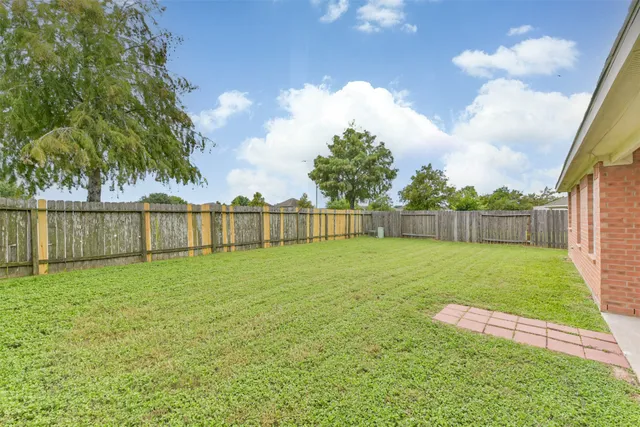 a view of a backyard with a garden and wooden fence