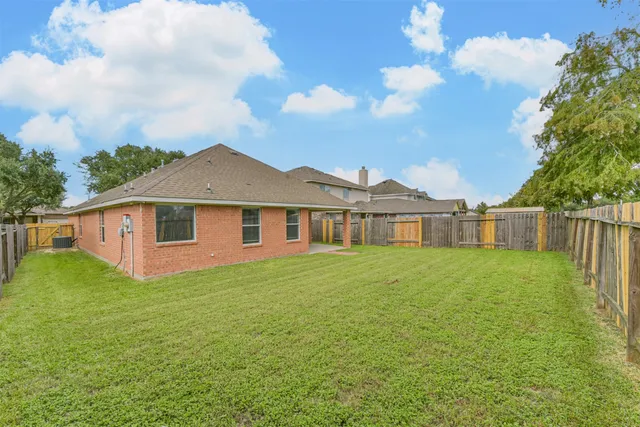a view of a yard in front of a house with a large tree