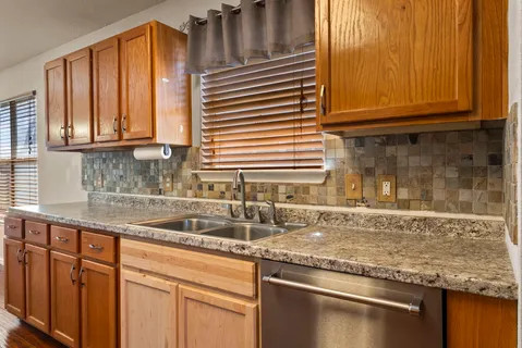 a kitchen with granite countertop a sink and cabinets