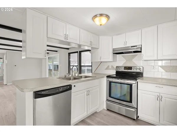 a kitchen with stainless steel appliances granite countertop a sink stove and cabinets