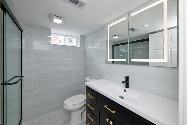 a bathroom with a toilet sink and mirror