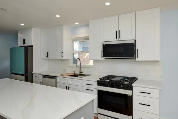 a kitchen with stainless steel appliances a stove a microwave and cabinets