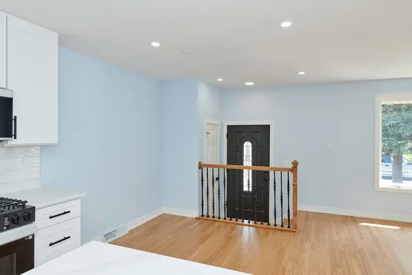 a hall with stainless steel appliances granite countertop a refrigerator and a stove top oven