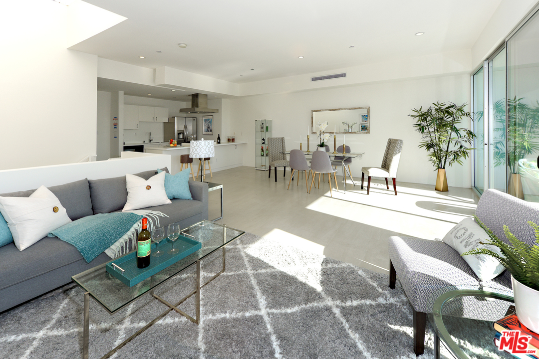 a living room with furniture a dining table and a potted plant