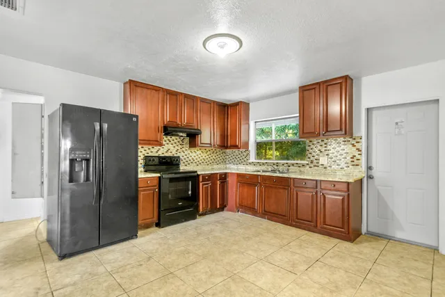 a kitchen with stainless steel appliances granite countertop a refrigerator and a sink