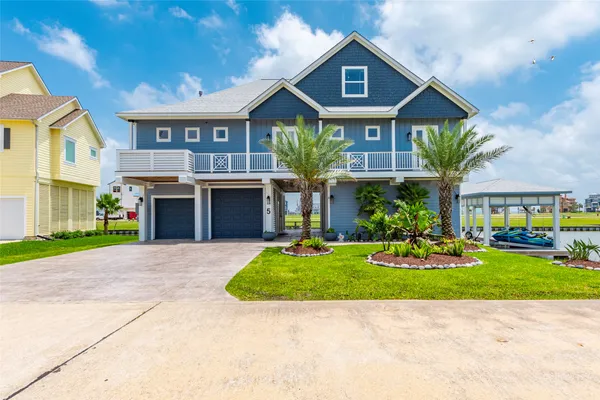 a view of a big house with a big yard and large trees