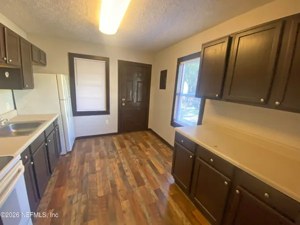 a kitchen with a sink and wooden floor