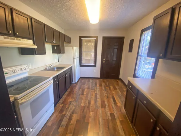 a kitchen with sink a refrigerator and a stove