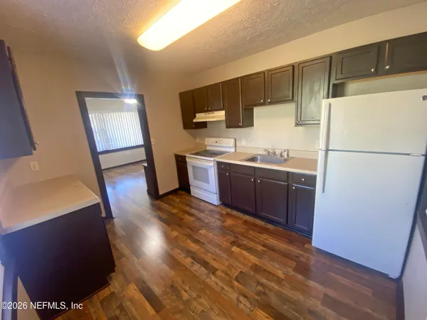 a kitchen with stainless steel appliances granite countertop a refrigerator a sink and a stove