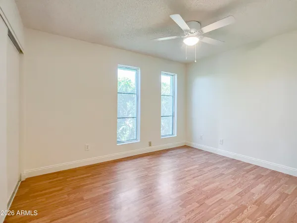 an empty room with wooden floor and windows