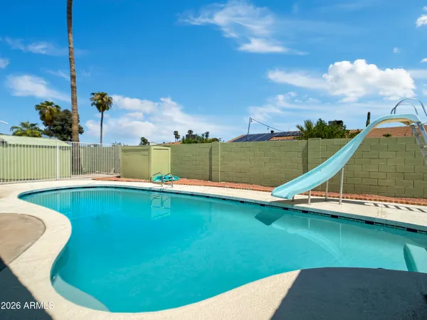 a view of a swimming pool with lawn chairs