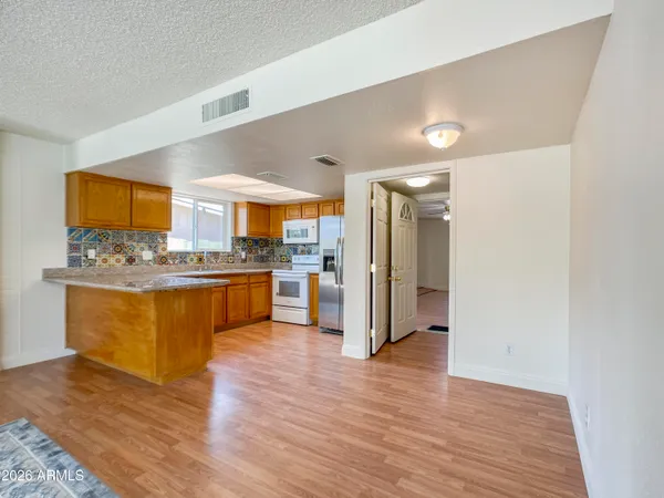 a large kitchen with a center island and wooden floor