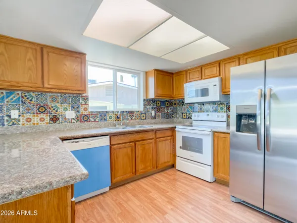 a kitchen with stainless steel appliances granite countertop a stove a sink and a refrigerator