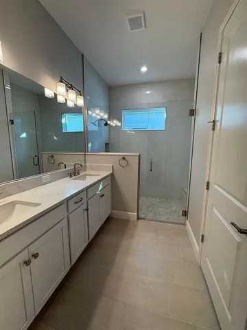 a spacious bathroom with double sink and shower