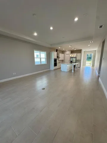 an open kitchen with kitchen island a sink a stove and a refrigerator