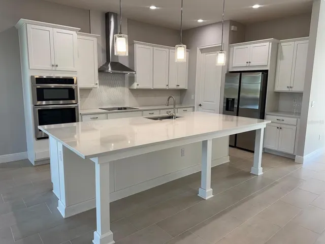 a kitchen with a stove a refrigerator and a sink