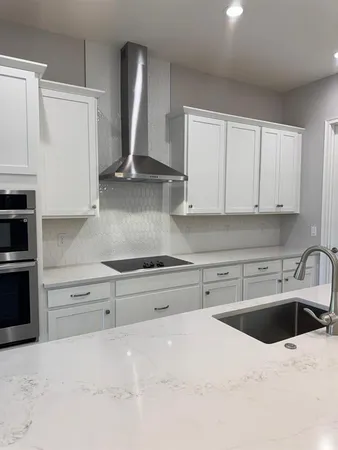 a kitchen with stainless steel appliances granite countertop a sink dishwasher stove and refrigerator