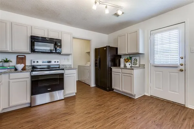 a kitchen with a refrigerator stove and wooden cabinets
