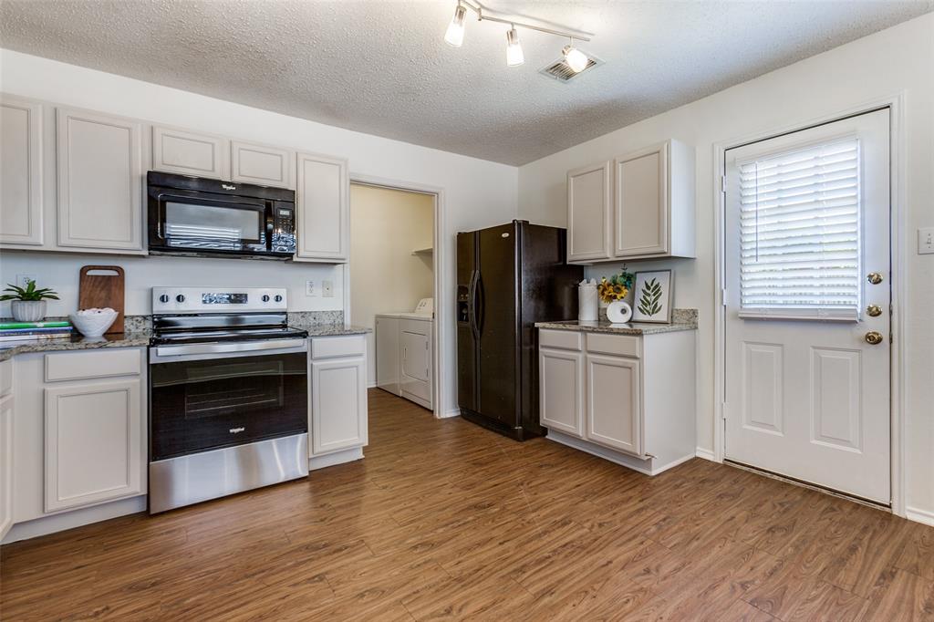a kitchen with a refrigerator stove and wooden cabinets