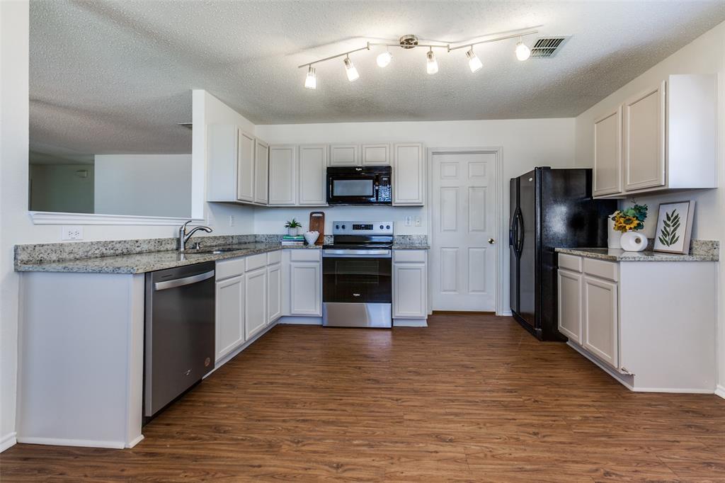 2613 Salt Maker Way Little Elm, TX 75068 - Photo 2 of 16 a kitchen with granite countertop a refrigerator stove top oven and sink
