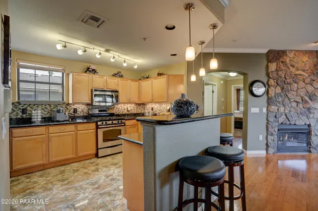 a kitchen with stainless steel appliances kitchen island granite countertop a sink and cabinets